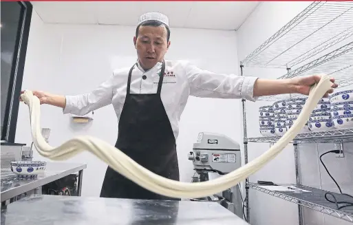  ?? STEVE RUSSELL/TORONTO STAR ?? Master noodle maker Ao Ma works the dough through stretching and kneading at Chinese noodle house Omni Palace.