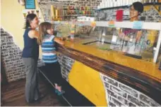  ?? Seth McConnell, Special to The Denver Post ?? Jaime Grimm-Rice and her daughter, Izzy Rice, order ice cream from Amber Lam at Scrumptiou­s in downtown Arvada last month.