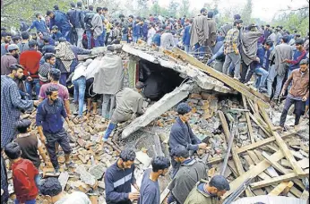  ?? WASEEM ANDRABI/HT ?? Villagers inspect the house damaged during an encounter at Chowgam in Kulgam district on Saturday.