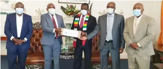  ??  ?? President Emmerson Mnangagwa (centre), receives 10 000 Covid-19 test kits donated by FBC from Herbert Nkala (FBCH Group chairperso­n — second from right) and John Mushayavan­hu (FBC Group CE — second from left). Looking on are Shingi Mabuto (PSMI Corporate Services executive director — far right) and Dr T.Gutu.