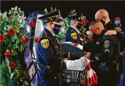  ?? Godofredo A. Vásquez / Staff photograph­er ?? Houston police Senior Officer Mark Medina, center, pays his respect Thursday during the memorial service for Sgt. Harold Preston at Grace Church Houston. Medina said Preston was his sergeant for 15 of the 21 years they knew each other.