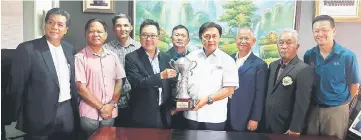  ??  ?? Mawan (fourth right) hands over the challenge trophy to Henry Chuo while Mazlan (third right) and others look on.