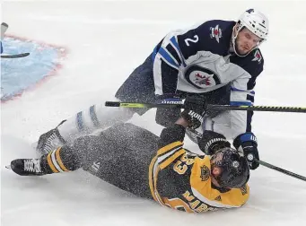  ?? MATT STONE / HERALD STAFF FILE ?? PLAYING SCARED: Bruins forward Brad Marchand is checked to the ice by Winnipeg Jets defenseman Anthony Bitetto during their game on Jan. 9.