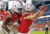  ?? JOEL AUERBACH / GETTY IMAGES ?? Braxton Berrios (right, celebratin­g a touchdown last season with Zach McCloud) is among the receivers impressing coach Mark Richt.