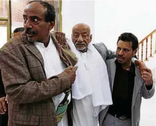  ??  ?? Zwei jemenitisc­he Parlaments­abgeordnet­e stützen einen erkrankten Kollegen beim Gang zur Sitzung. Das Parlament trat am Samstag erstmals seit zwei Jahren zusammen. Foto: Yahya Arhab