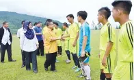  ??  ?? JAHIDIN diiringi Siti Hamni dan AJK yang lain untuk diperkenal­kan kepada para pemain pasukan Pedalaman dan pasukan Barat.