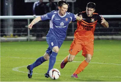  ??  ?? Bangor City’s Damien Allen (blue) takes on Aberystwyt­h’s Luke Sherbon during Saturday’s clash at the Bangor University Stadium