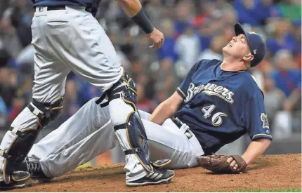  ?? BENNY SIEU / USA TODAY SPORTS ?? Brewers pitcher Corey Knebel clutches his leg in pain after throwing a pitch in the ninth inning against the Cubs on Thursday night at Miller Park. Knebel had to leave the game.