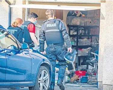  ??  ?? Members of the operationa­l team inspect the garage of a property.