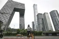  ?? AGENCE FRANCE PRESSE ?? A woman rides a bike at central business district in Beijing.