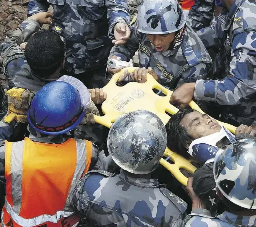  ?? AFP / Getty Images ?? Pempa Tamang, 15, centre, survived under a collapsed building in Kathmandu for five days on two cans of butter.