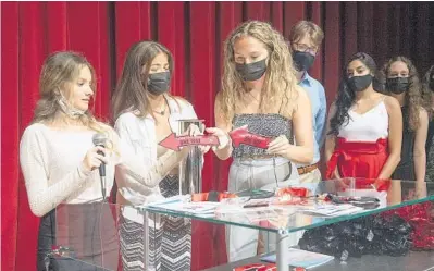  ?? MICHAEL LAUGHLIN/SOUTH FLORIDA SUN SENTINEL ?? Cooper City High School students Summer Testa, from left, Victoria Pera, Emily Aaron and others fill a time capsule Wednesday, which will be placed in the school’s Media Center and opened in 50 years.