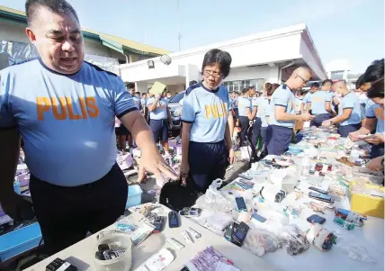  ?? JOY TORREJOS ?? Police Regional Office-7 director Chief Supt. Debold Sinas inspects the contraband items seized from Cebu Provincial Detention and Rehabilita­tion Center during a greyhound operation yesterday. Story on Page 4.