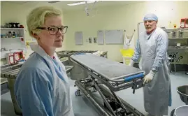  ??  ?? Mortuary technician­s Simone Hall and Pat Mahoney spend their days dealing with the dead. It can be a messy job, hence the need for protective equipment.