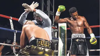  ?? GLADSTONE TAYLOR ?? Michael ‘Wasp’ Gardener (right) celebrates as referee Peter Richards stops the fight after Jason Kelly (on ground) is knocked down a second time in the first round in the Wray and Nephew Contender Series at the Chinese Benevolent Associatio­n auditorium...