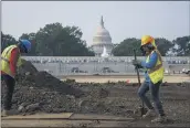  ?? J. SCOTT APPLEWHITE — THE ASSOCIATED PRESS ?? Workers repair a park near the Capitol in Washington. Senators working on the infrastruc­ture plan hope to have a bill ready to be voted on next week.