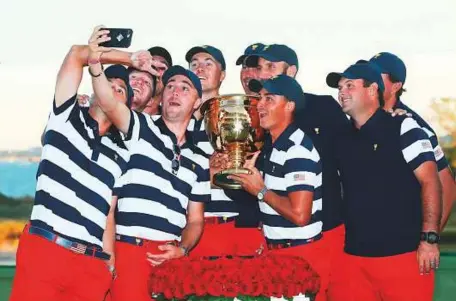  ?? AFP ?? The US team celebrate with the trophy after defeating Internatio­nal Team 19-11 in the Presidents Cup at Liberty National Golf Club in Jersey City, New Jersey, on Sunday.