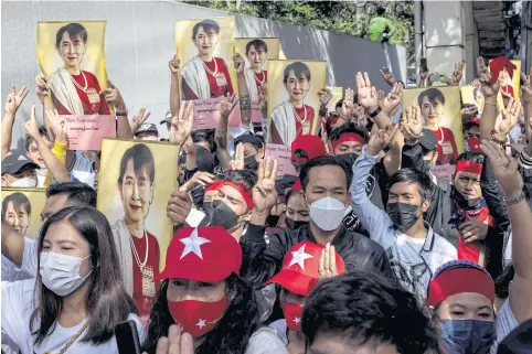  ?? AFP ?? Myanmar protesters hold up pictures of detained Myanmar civilian leader Aung San Suu Kyi outside the Embassy of Myanmar in Bangkok on Monday.