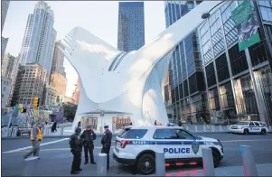  ?? AP PHOTO ?? Members of the Port Authority Emergency Services Unit stand watch outside the World Trade Center Transporta­tion Hub Thursday in New York.