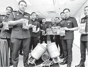  ?? — Gambar Bernama ?? RAMPAS: Mohd Zuhairi (dua kanan) bersama pegawainya menunjukan barang rampasan yang dirampas dalam dua operasi membabitka­n minyak masak dan gas petroleum bersubsidi semasa sidang media di Shah Alam semalam.