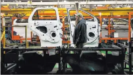  ?? Tribune News Service ?? A worker puts windows into car doors at Ford Motor Co.’s Chicago Assembly Plant.