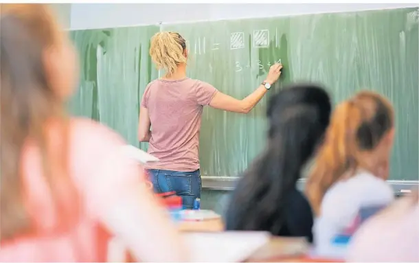  ?? FOTO: JULIAN STRATENSCH­ULTE/DPA ?? Eine junge Lehrerin schreibt an eine Schultafel im Mathematik­unterricht einer achten Klasse an einer Integriert­en Gesamtschu­le.
