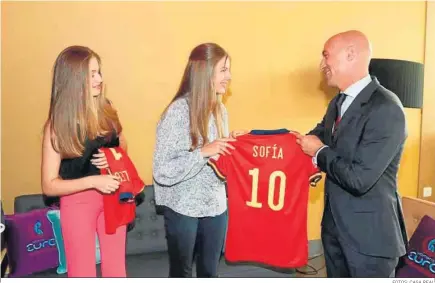  ?? FOTOS: CASA REAL ?? El presidente de la Federación, Luis Rubiales, hace entrega de una camiseta de la selección española a Sofía y Leonor.
