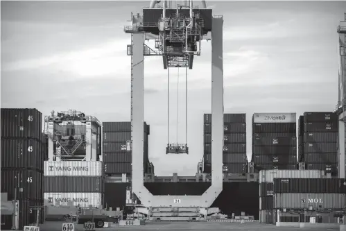  ?? Associated Press ?? ■ A ship-to-shore crane prepares to load a 40-foot shipping container onto a container ship July, 5, 2018, at the Port of Savannah in Savannah, Ga. The higher costs resulting from the tariffs have yet to inflict much overall damage to a still-robust American economy, which is less reliant on internatio­nal trade than most other countries are. Spurred by lower taxes, the economy grew at an impressive 3.4 percent annual rate from July through September after having surged 4.2 percent in the previous quarter. And employers added 2.6 million jobs last year, the most since 2015.