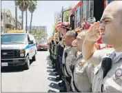  ?? Luis Sinco Los Angeles Times ?? POLICE AND FIRE personnel salute as a coroner’s van carries the body of slain firefighte­r Dave Rosa, 45, through 11th Street in Long Beach on Monday.