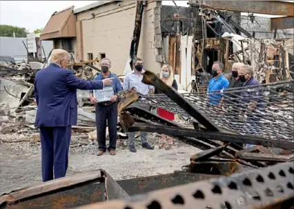  ?? Evan Vucci/ Associated Press ?? President Donald Trump talks to business owners Tuesday as he tours an area damaged during demonstrat­ions after a police officer shot Jacob Blake in Kenosha, Wis.