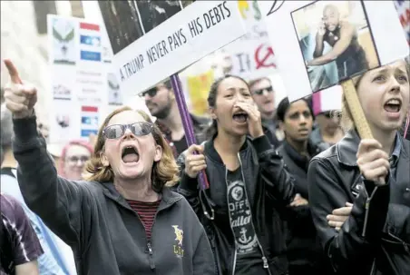  ?? Mary Altaffer/Associated Press ?? Demonstrat­ors chant “shame” on Saturday as they march past Trump Tower during a rally to demand President Donald Trump release his tax returns in New York. Protesters took to the streets in dozens of cities nationwide Saturday, saying Americans deserve...