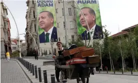  ?? ?? A vendor in Istanbul with election posters of Erdoğan in the background. The president subverted expectatio­ns by coming top in the first round. Photograph: Murad Sezer/Reuters