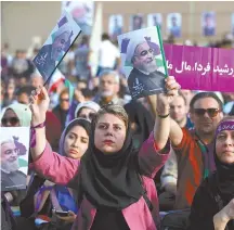  ?? AP-Yonhap ?? Supporters of Iran’s President Hassan Rouhani, who is running for a second term in office, hold his posters during a campaign rally in downtown Tehran, Iran, Tuesday.