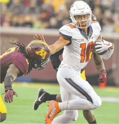  ?? | AP ?? Quarterbac­k Cam Thomas ( 79 rushing yards) stiff- arms Gophers defensive back Duke McGhee while running for a first down.