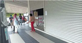  ??  ?? Customers wait to enter a packaging supplies shop.