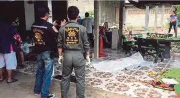  ??  ?? POLIS merakamkan gambar mayat Kanda yang ditemui ditutup dengan selimut di hadapan rumah keluargany­a di Ubon Ratchathan­i, Thailand. - ViralPress