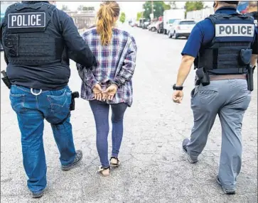  ?? Kent Nishimura Los Angeles Times ?? ADRIANA ESPEJEL is escorted away by ICE fugitive operations team members in Compton on June 10.