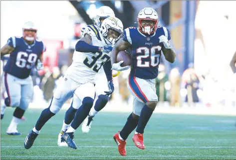  ?? AP PHOTO ?? New England Patriots running back Sony Michel (26) runs away from Los Angeles Chargers free safety Derwin James (33) during the first half of an NFL divisional playoff game, Sunday.