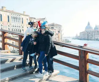  ??  ?? Tradizione
A causa della pandemia poca gente sui ponti e per le calli di Venezia durante il Carnevale