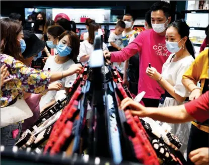  ?? GUO CHENG / XINHUA ?? Consumers purchase goods at a duty-free shop on Oct 5 in Sanya, Hainan province, where duty-free shops’ revenues soared during the National Day holiday.