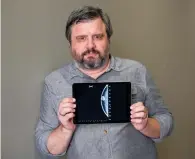  ?? AP PHOTO/RICHARD VOGEL ?? In this July 13 photo, Associated Press reporter Andrew Dalton holds an iPad displaying an image of his mammogram in downtown Los Angeles. Dalton described his experience as the rare man who underwent a mammogram in a story for the AP.