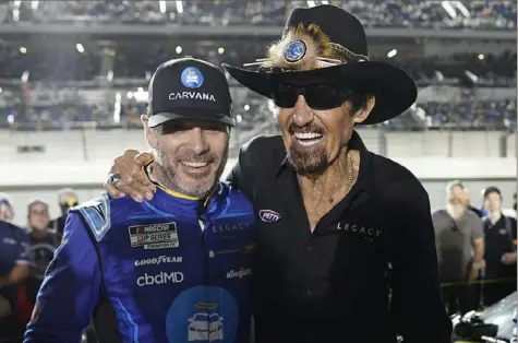  ?? Chris Graythen/Getty Images ?? THE PAST COMES ALIVE Legacy Motor Club team owners Jimmie Johnson, left, and Richard Petty pose for photos prior to the start of the Duels Thursday night at Daytona Internatio­nal Speedway. Johnson earned a spot in Sunday’s field with his qualifying effort Wednesday night.