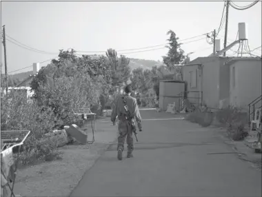  ?? Associated Press ?? An Israeli soldier walks past trailers at the unauthoriz­ed West Bank Jewish outpost of Nofei Nehemya on Monday. A government-appointed committee is recommendi­ng that Israel legalize dozens of unauthoriz­ed West Bank settlement.