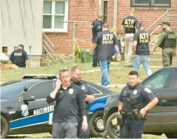  ?? AMY DAVIS/BALTIMORE SUN MEDIA ?? Baltimore City Police and ATF officers search for evidence in the aftermath of 30 people being shot at a Brooklyn Homes block party.