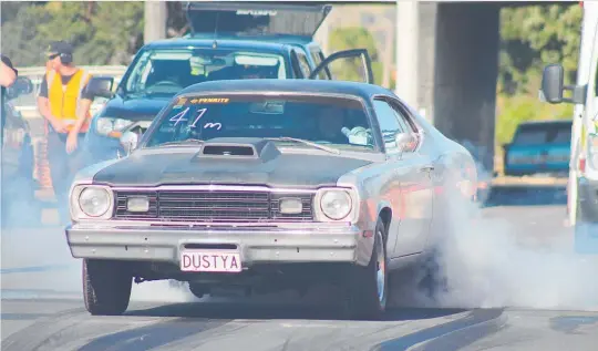  ?? Photos / Phillip Hoskyn ?? Shawn Graham smokes the tyres in his Plymouth Duster at the 33rd Street Drags up Taupo Quay on Sunday.