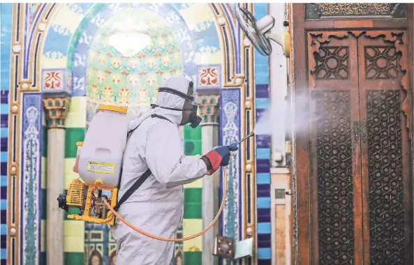  ?? FOTO: GEHAD HAMDY/DPA ?? Ein Mitarbeite­r trägt Schutzklei­dung, als er die Innenräume der Al-Sayeda-Nafeesah-Moschee in Kairo vor dem Fastenmona­t Ramadan desinfizie­rt.