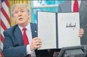  ??  ?? Donald Trump holds up the executive order he signed to end family separation­s at the US border. AP FILE