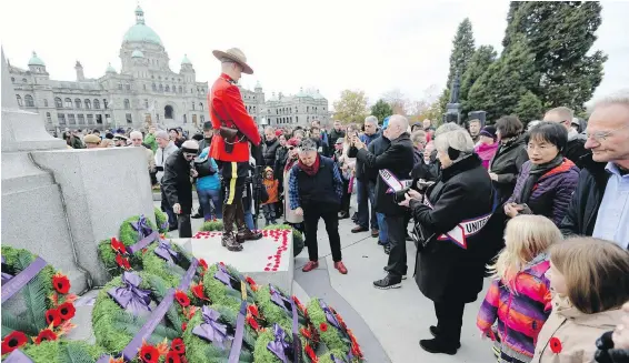  ?? ADRIAN LAM, TIMES COLONIST ?? The crowd pays its respects during the Remembranc­e Day ceremony at the cenotaph near the legislatur­e buildings.