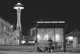 ??  ?? Dave Chung, who says he has been homeless for five years on the streets of California and Washington state, eats a meal last month before bedding down in a bus shelter in view of the Space Needle in Seattle.