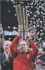  ?? DAVID J. PHILLIP/THE ASSOCIATED PRESS ?? Alabama head coach Nick Saban holds up the championsh­ip trophy Monday after his Crimson Tide won the national title game.